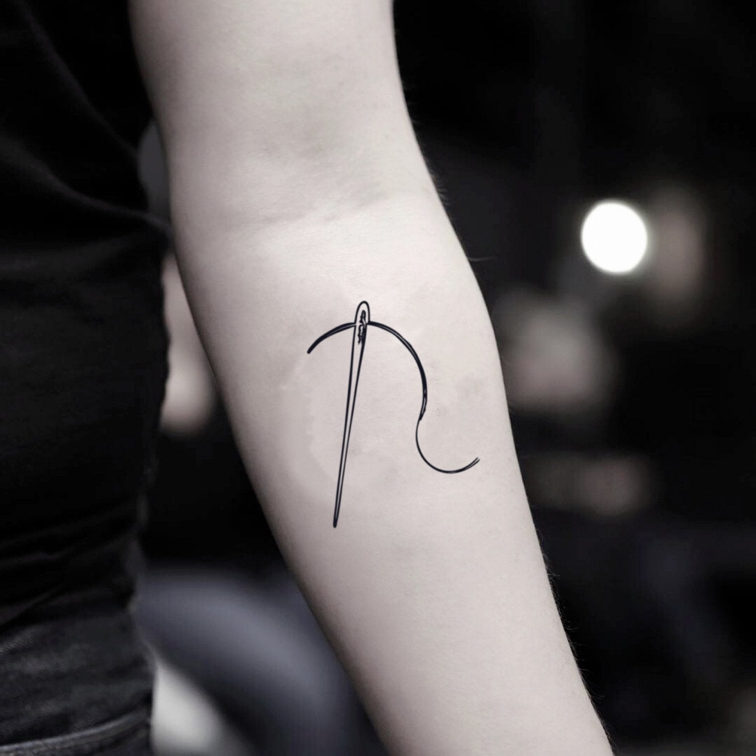 fake small sewing needle and thread minimalist temporary tattoo sticker design idea on inner arm